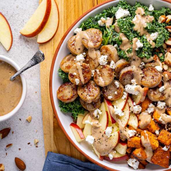 A fresh salad bowl with kale, apples, sweet potatoes, and Al Fresco Sweet Apple Chicken Sausage
