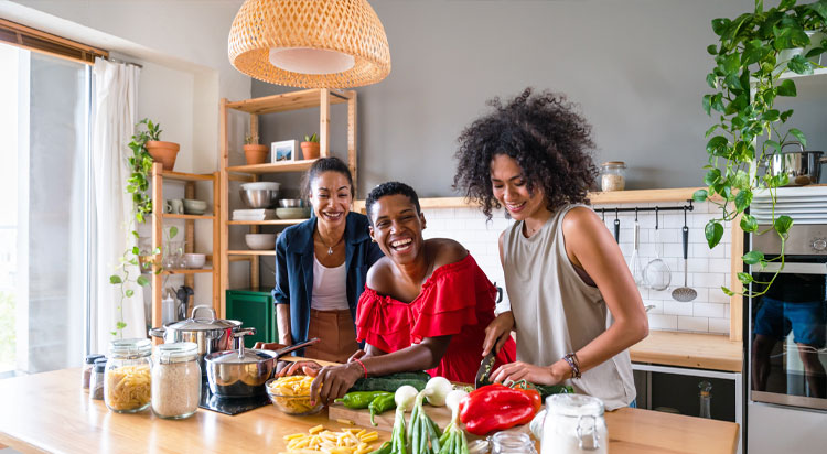 Friends preparing dinner in a bright kitchen with fresh ingredients