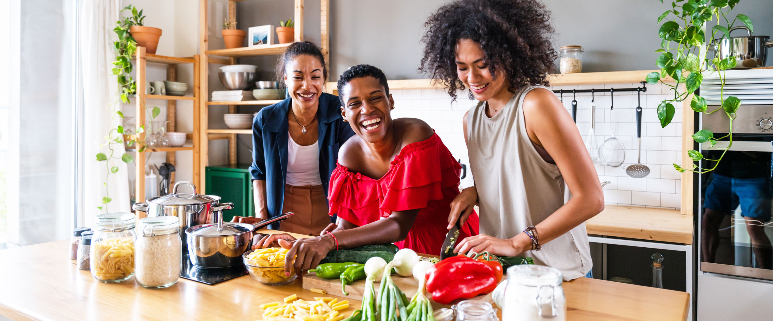 Friends preparing dinner in a bright kitchen with fresh ingredients