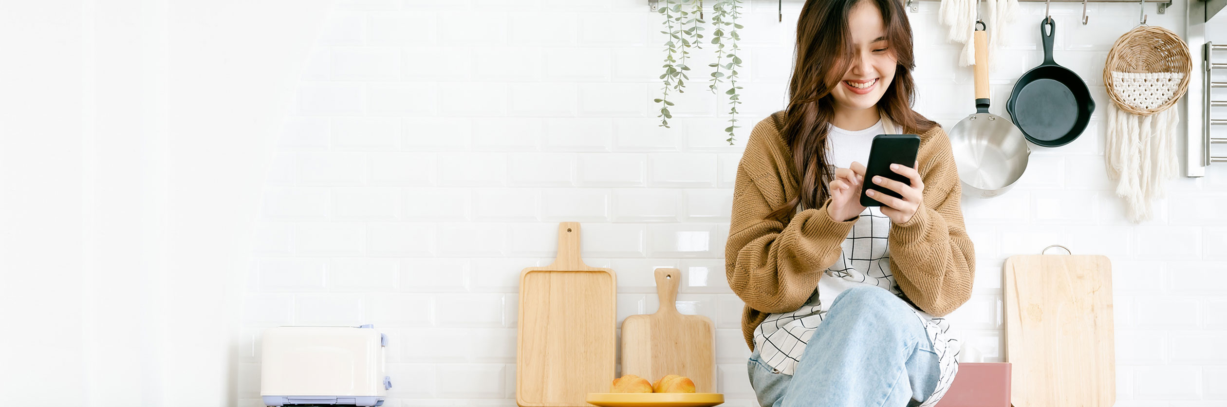 Woman in a kitchen using her phone to contact Al Fresco