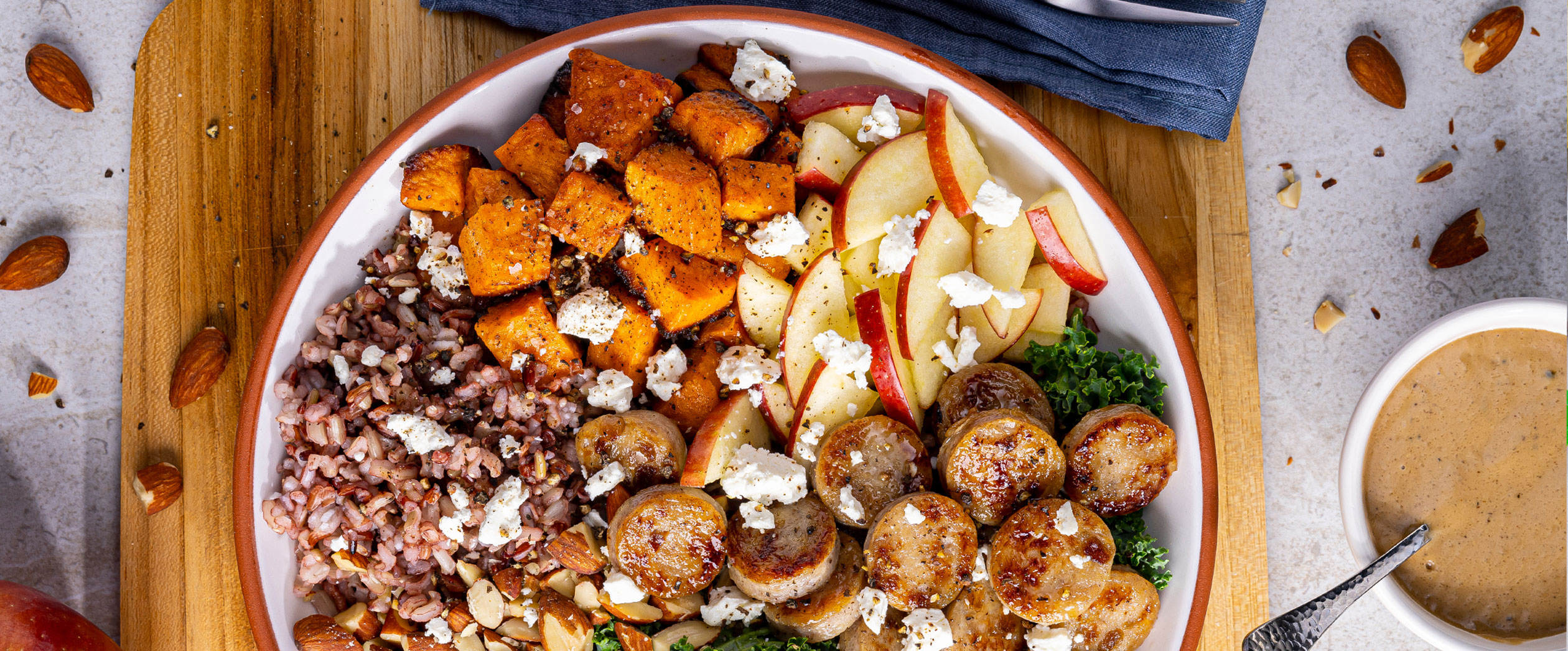 Fresh bowl of apple, kale, sweet potato, and Al Fresco Apple Chicken Sausage